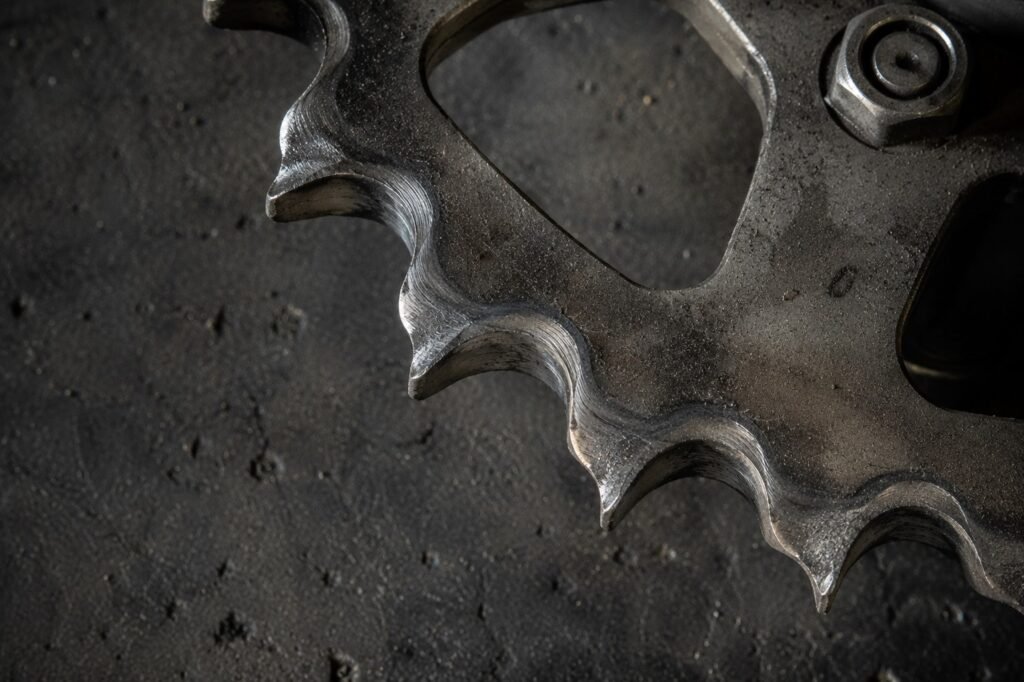 Worn hooked motorcycle sprocket teeth showing shark fin wear pattern