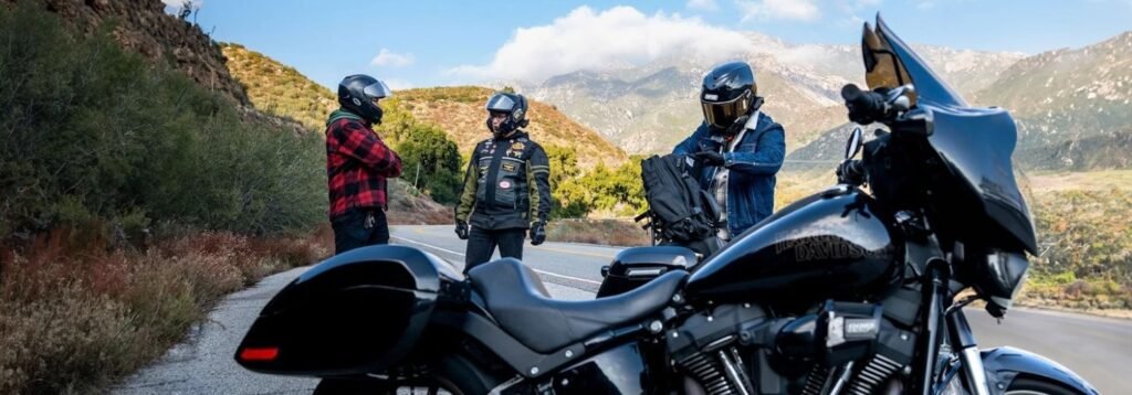Motorcyclists taking a break on a mountain road, one wearing a Viking Bags motorcycle backpack