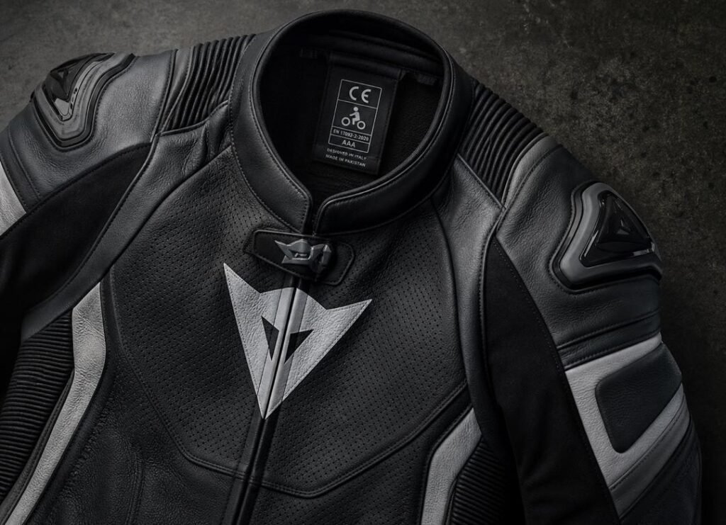 Premium motorcycle riding suit showing CE certification label and triple stitching detail