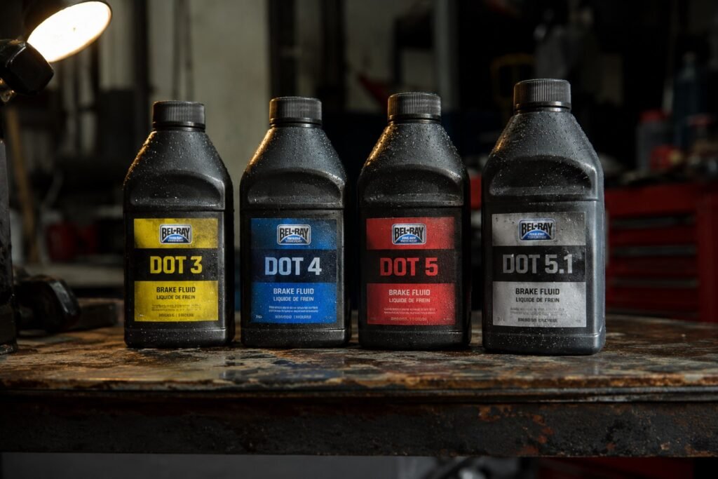 DOT 3, DOT 4, DOT 5 and DOT 5.1 brake fluid bottles lined up on a workshop bench