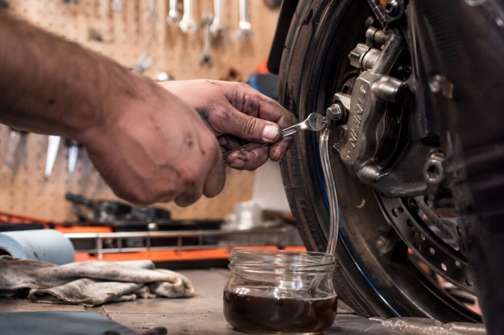 Mechanic bleeding motorcycle front brake caliper in home