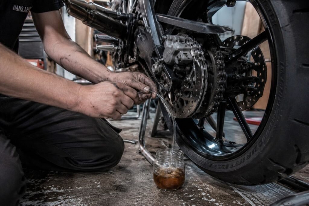 Bleeding the rear brake caliper on a motorcycle with clear tubing and jar