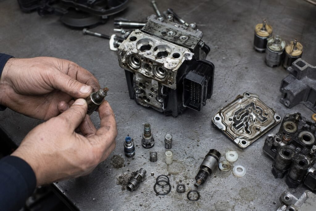 Disassembled motorcycle ABS module showing corrosion damage from contaminated brake fluid