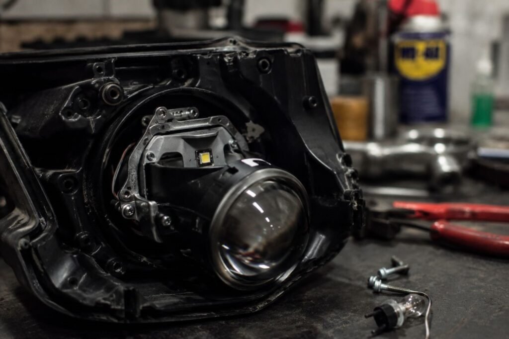 Close up of motorcycle projector headlight housing with LED bulb installed in garage