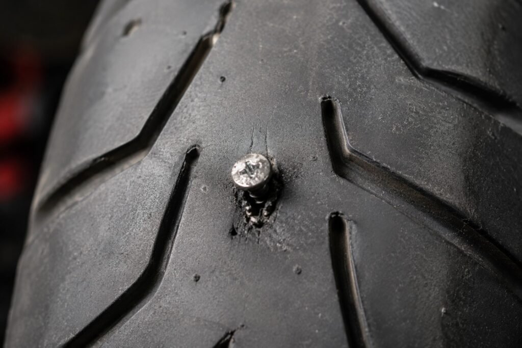 Screw embedded in a motorcycle tire tread causing a puncture