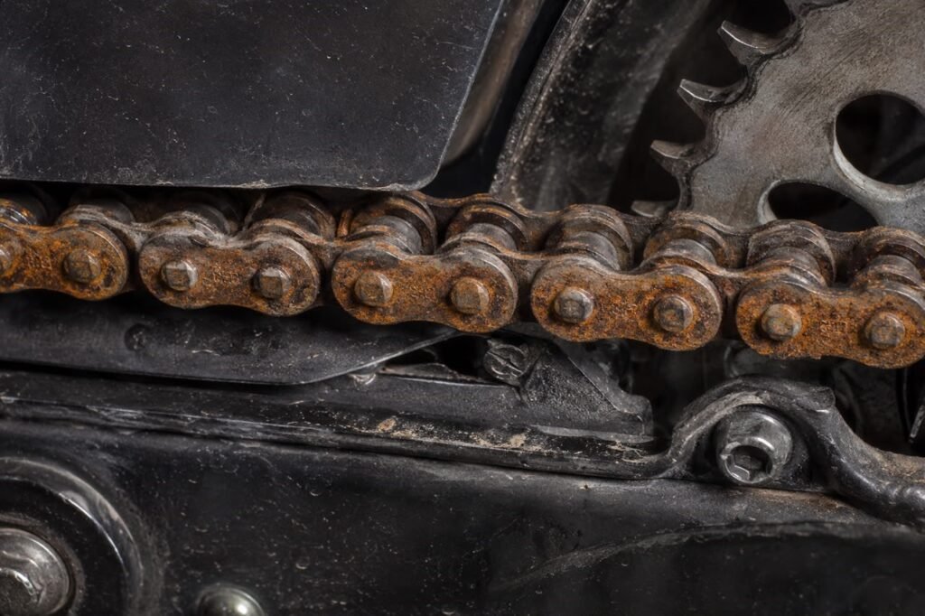 Dry rusty motorcycle chain showing signs of neglect and lack of lubrication