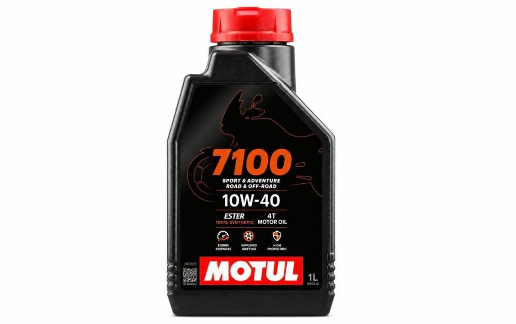 A 1-liter black bottle of Motul 7100 4T 10W-40 100% synthetic Ester motorcycle engine oil with a red cap