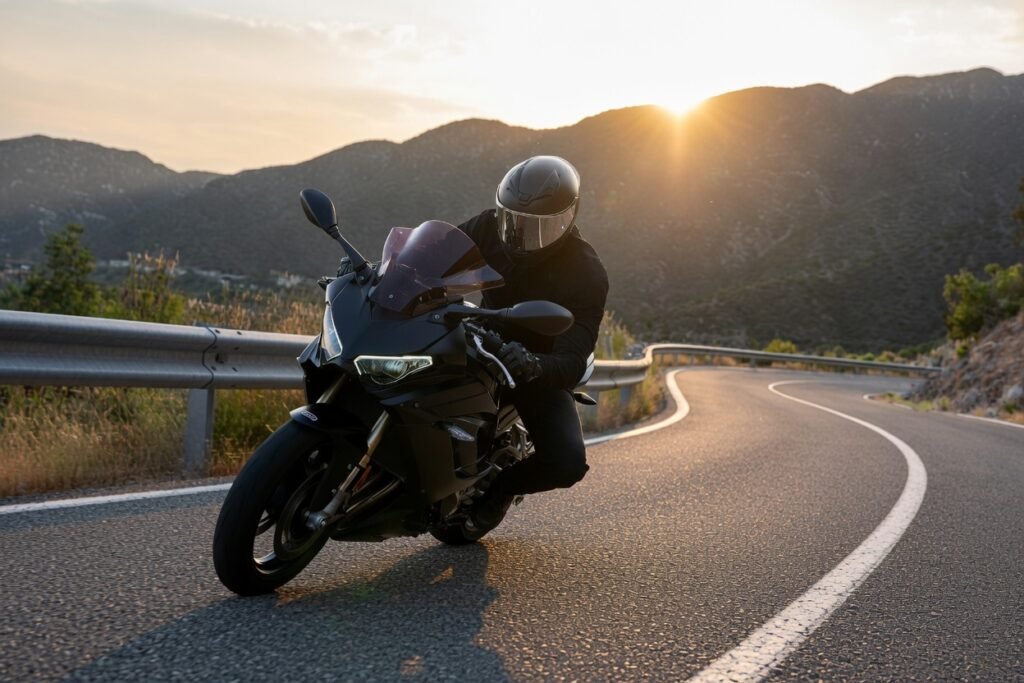 Motorcyclist riding a mountain highway at sunset wearing a smart motorcycle helmet