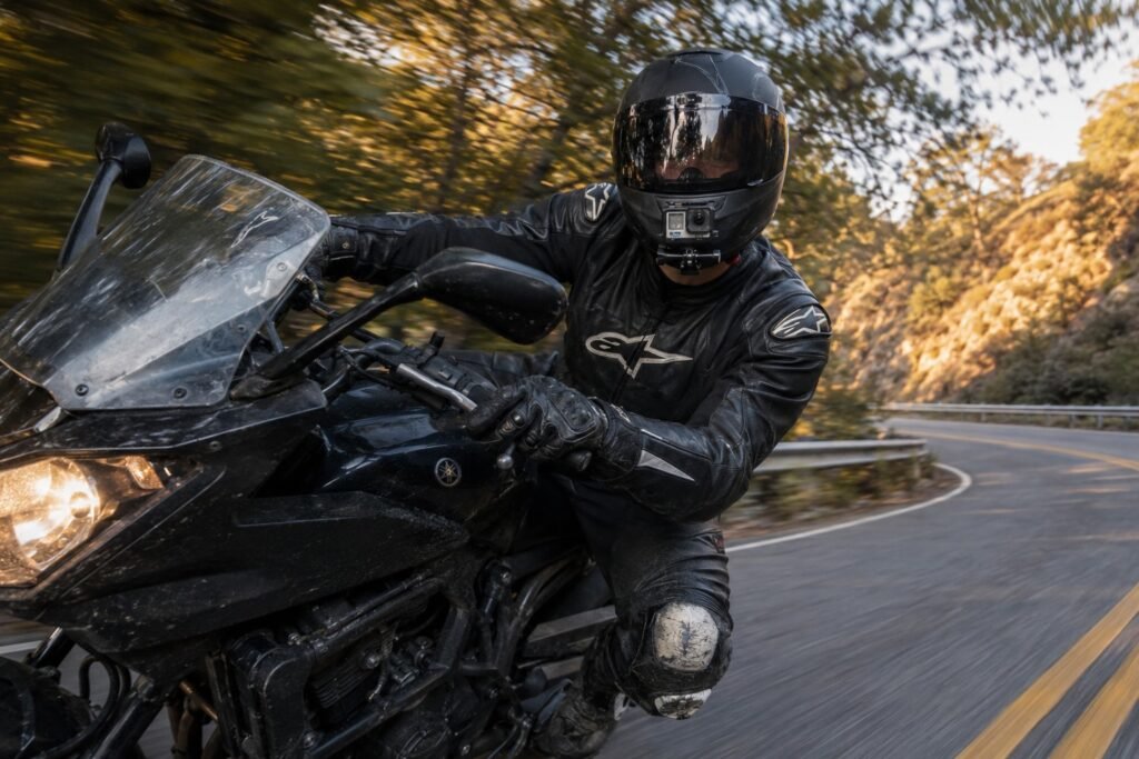 Motorcycle rider leaning into a corner with an action camera mounted on the helmet, GoPro vs DJI Osmo Action motorcycle test
