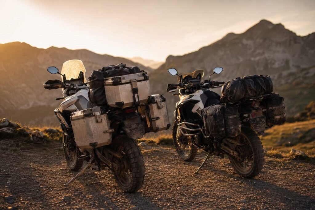 Hardside vs softside motorcycle luggage comparison showing aluminum panniers and soft roll-top saddlebags on adventure motorcycles