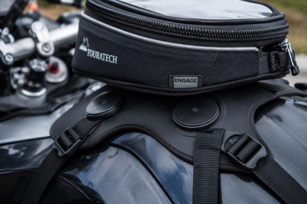 Close-up comparison of a magnetic tank bag base versus a strap-mounted tank bag