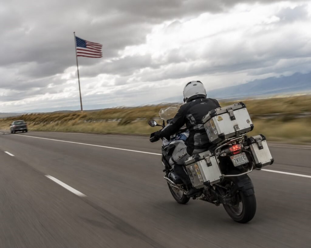 Motorcyclist riding on a highway leaning into a crosswind with a top box mounted