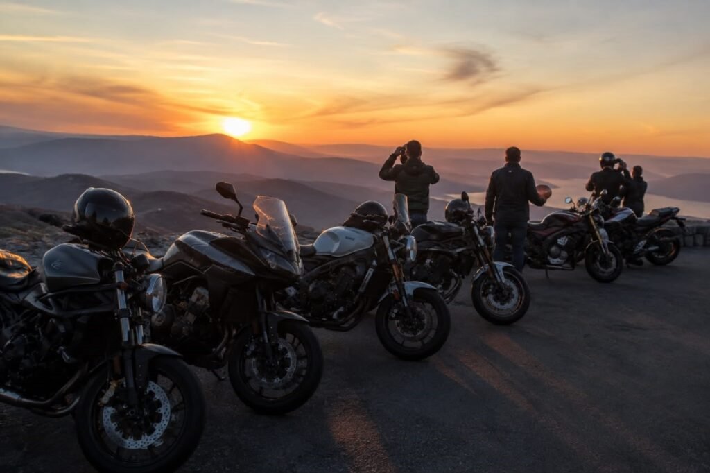 Group of motorcyclists at a scenic overlook at sunset after a day of riding