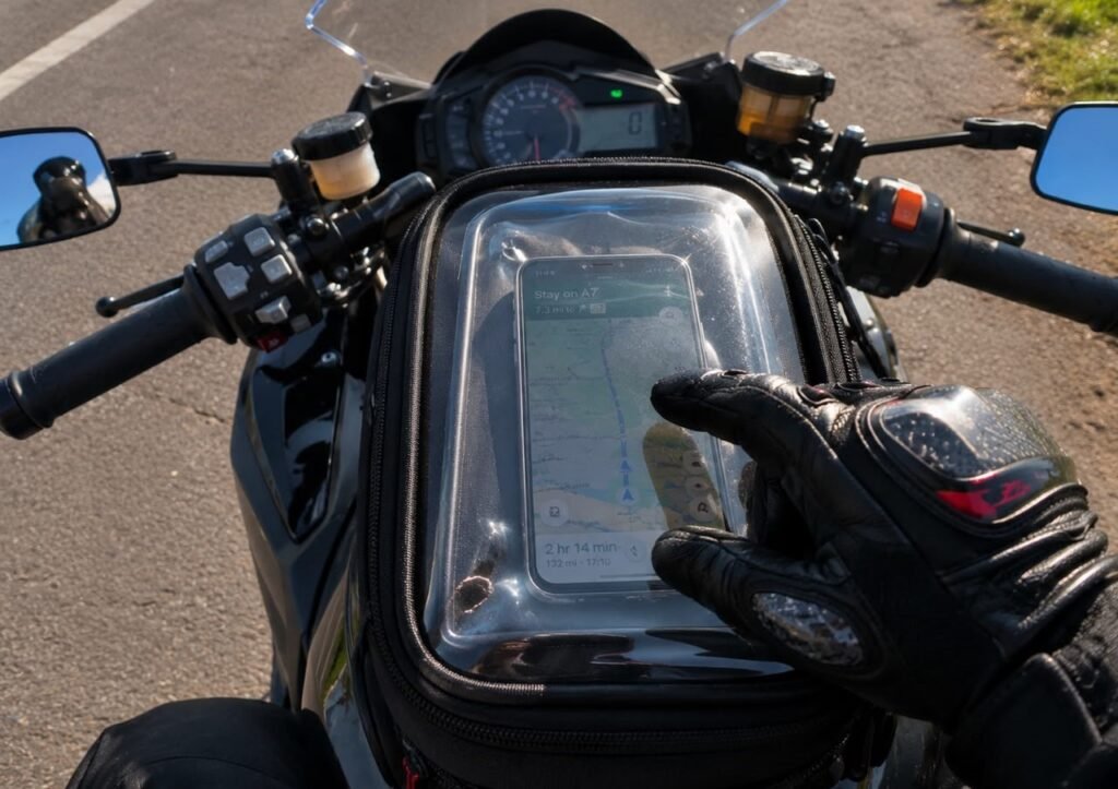 Smartphone in a tank bag's clear touchscreen window used for navigation