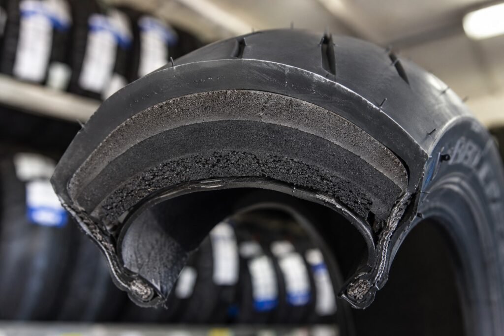 Cross-section cutaway of a motorcycle tire showing dual compound rubber layers