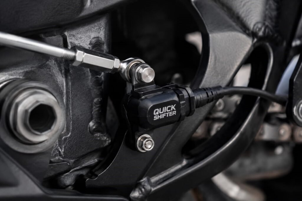 Close-up of a strain gauge quickshifter sensor mounted on a motorcycle shift rod