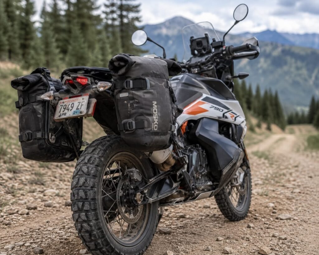 Soft throw-over saddlebags strapped to an adventure motorcycle on a gravel trail