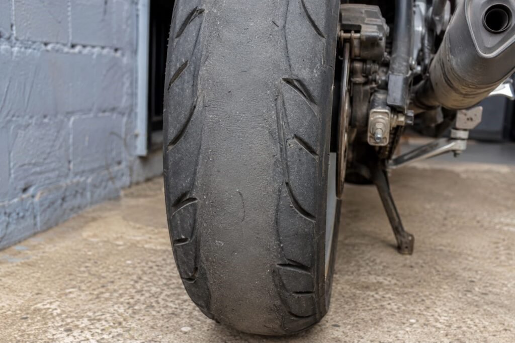 Worn motorcycle rear tire showing squared-off tread pattern from highway wear